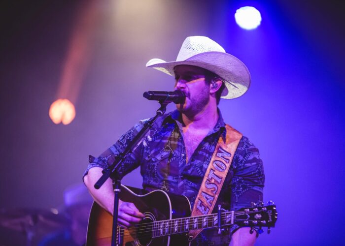 Easton Corbin in concert, singing while playing the guitar