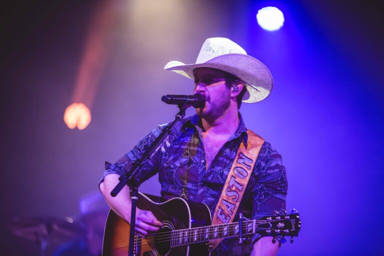 Easton Corbin in concert, singing while playing the guitar